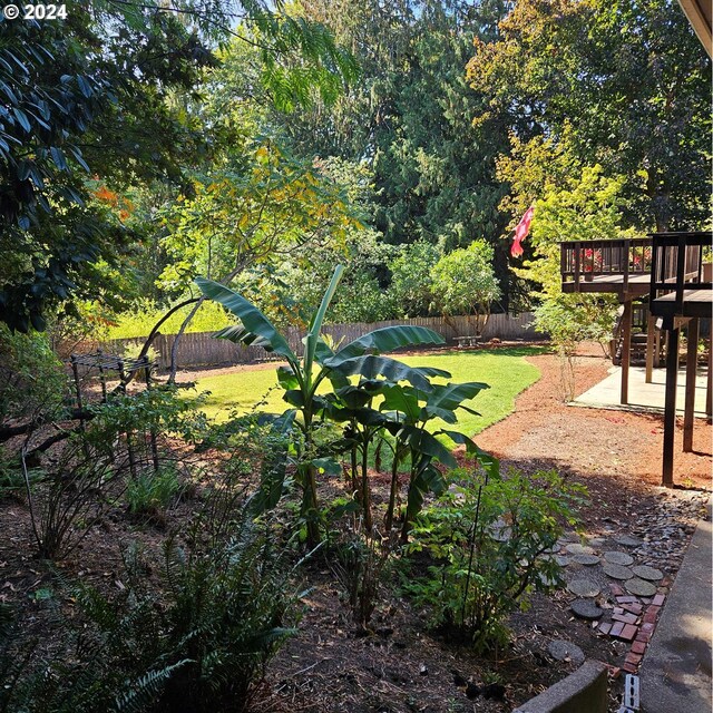view of yard with a patio, fence, and a wooden deck