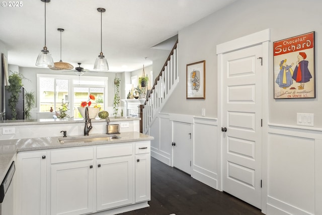 kitchen featuring a sink, decorative light fixtures, a wainscoted wall, white cabinetry, and dark wood-style flooring