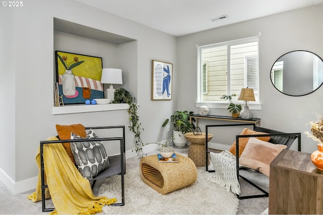 living area featuring baseboards and visible vents