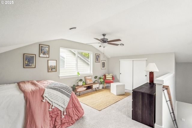 carpeted bedroom featuring a closet, lofted ceiling, and ceiling fan