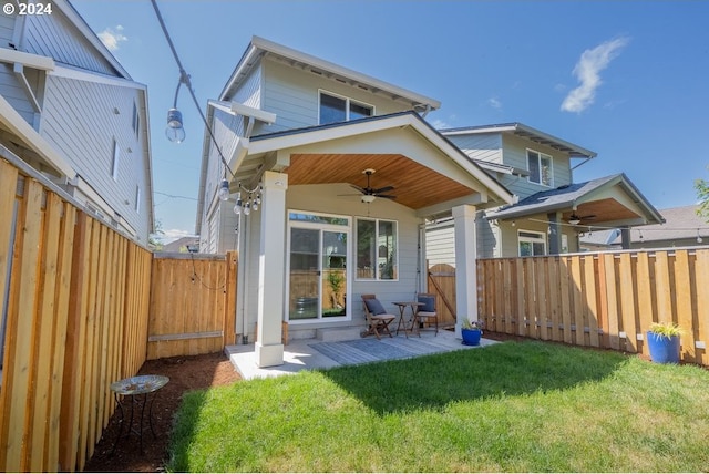 back of house with a fenced backyard, a yard, and a ceiling fan