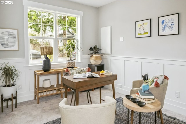 sitting room with a decorative wall, carpet, and a wainscoted wall