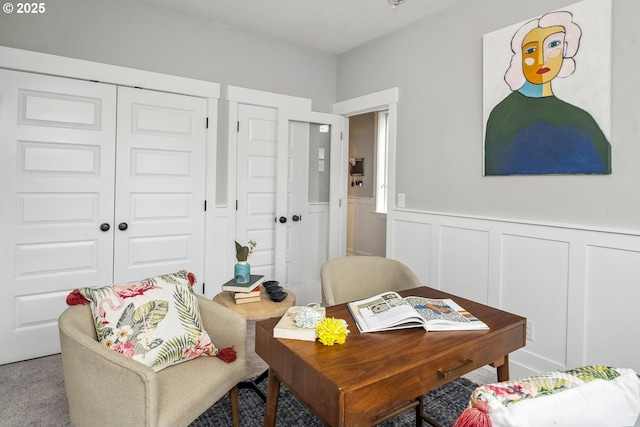 office space featuring a decorative wall and a wainscoted wall