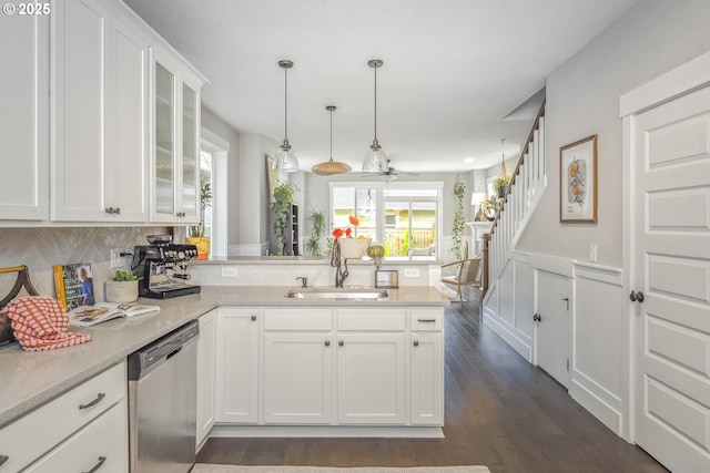 kitchen with a sink, white cabinetry, a peninsula, light countertops, and dishwasher