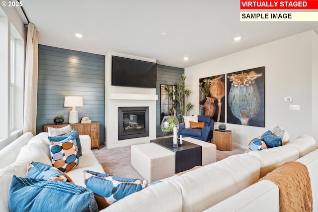 carpeted living area with recessed lighting and a fireplace