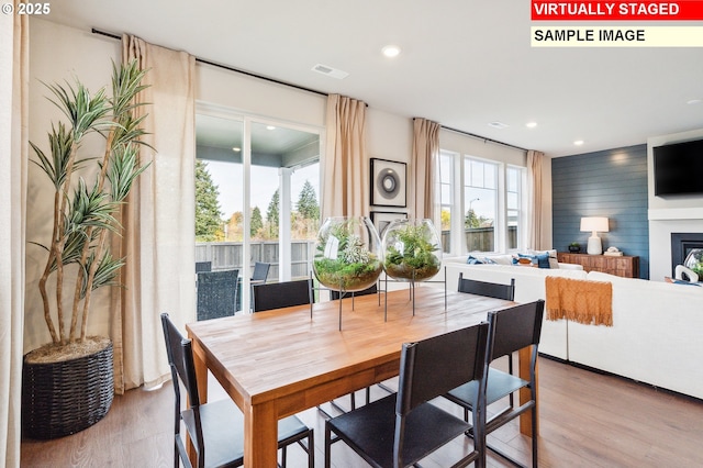 dining room featuring visible vents, recessed lighting, a fireplace, and wood finished floors