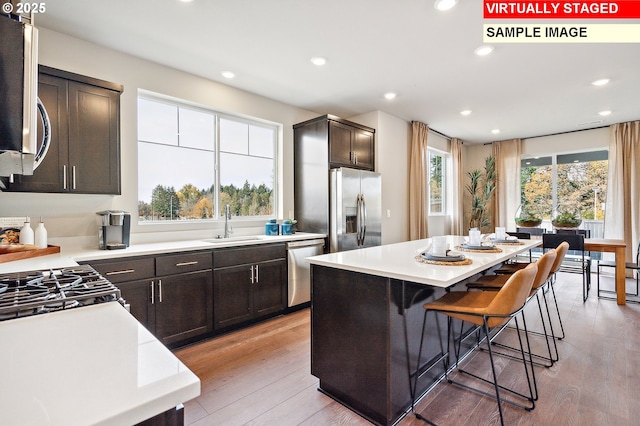 kitchen featuring a sink, light wood-style floors, appliances with stainless steel finishes, and light countertops