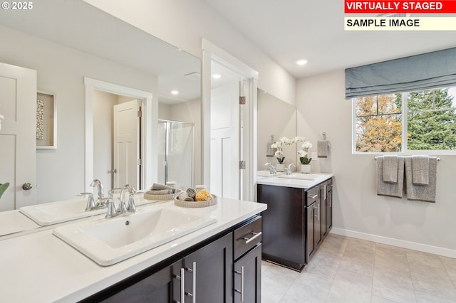 bathroom with a shower stall, baseboards, and a sink