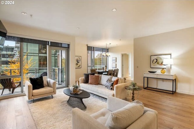 living area with baseboards, an inviting chandelier, and wood finished floors