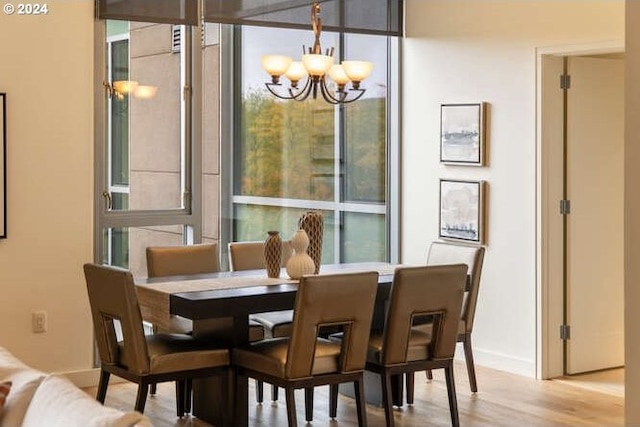 dining area featuring an inviting chandelier, baseboards, and wood finished floors