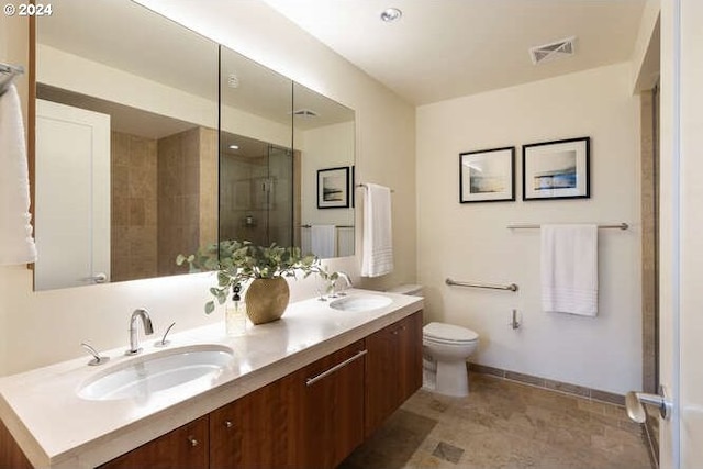 full bathroom with toilet, visible vents, a sink, and a shower with shower door