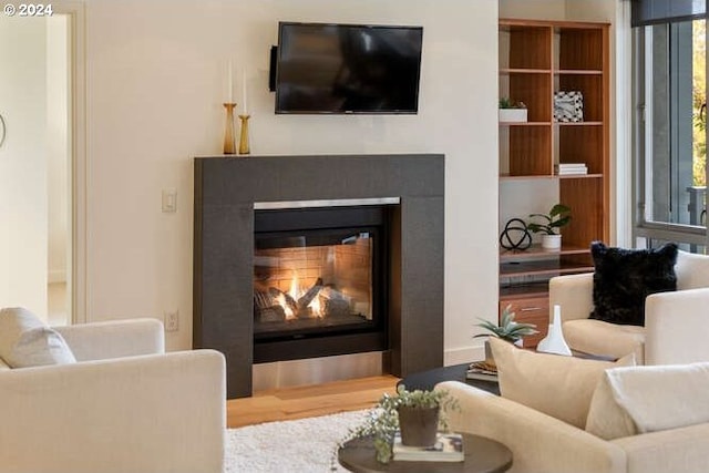 sitting room with wood finished floors and a glass covered fireplace