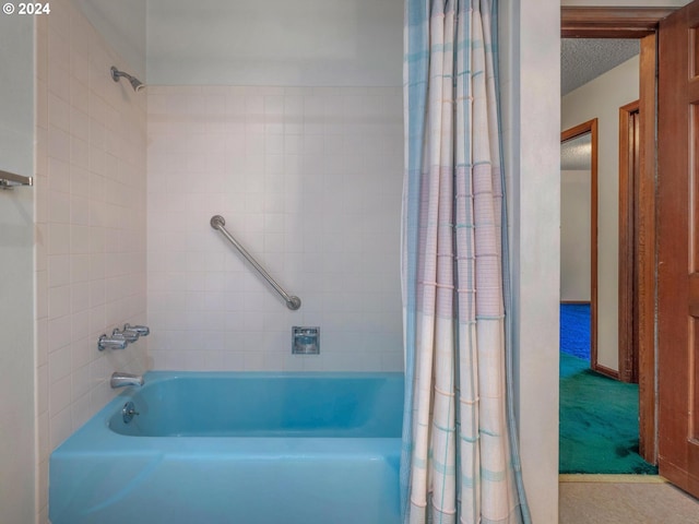 bathroom featuring shower / bathtub combination with curtain and a textured ceiling