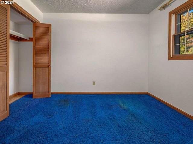 unfurnished bedroom with a textured ceiling, a closet, and carpet flooring