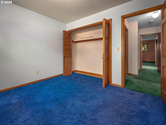 unfurnished bedroom featuring a closet, dark carpet, and a textured ceiling