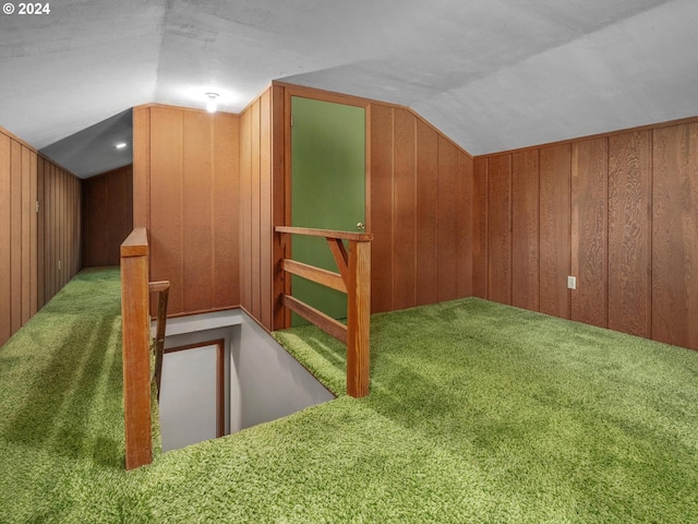 bonus room featuring wood walls, carpet floors, and vaulted ceiling