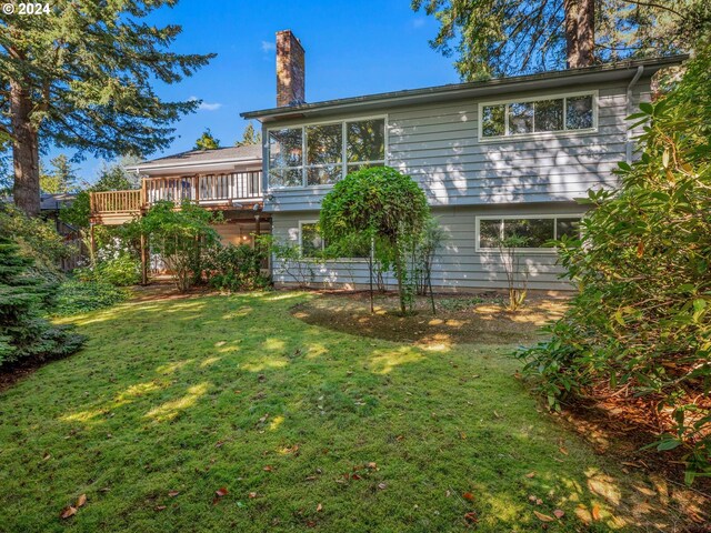 rear view of house featuring a yard and a wooden deck