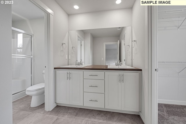 bathroom with vanity, a shower with shower door, and toilet