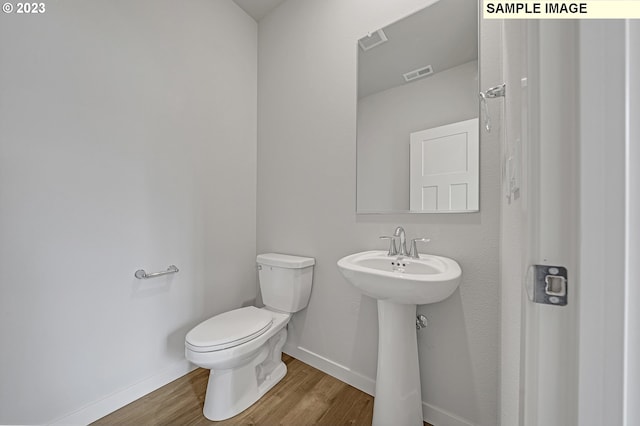 bathroom featuring wood-type flooring and toilet