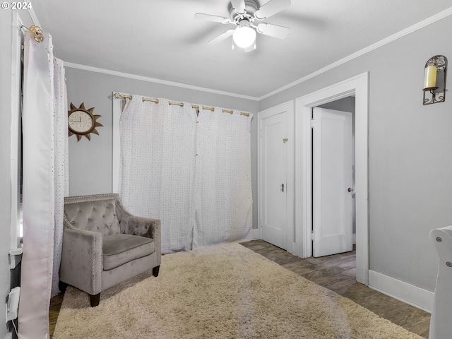 living area featuring wood-type flooring, ceiling fan, and crown molding