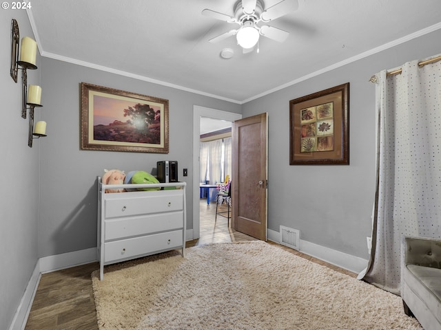 bedroom with ornamental molding, wood-type flooring, and ceiling fan