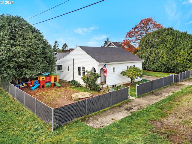 view of front of property featuring a front lawn and a playground