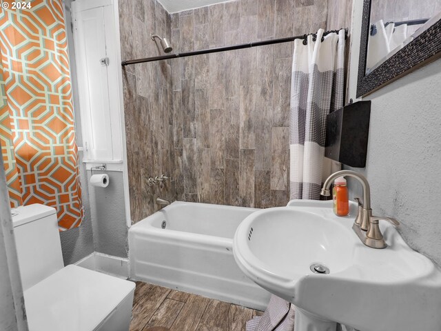 616 Park Ave, Tillamook, OR 97141 - bathroom featuring toilet, wood finished floors, a sink, shower / bath combo with shower curtain, and a textured wall