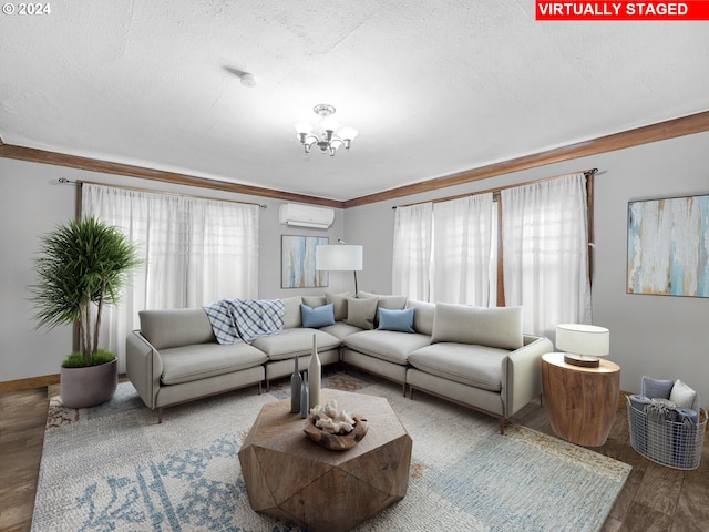 living room with wood-type flooring, an inviting chandelier, a wall mounted AC, a textured ceiling, and ornamental molding