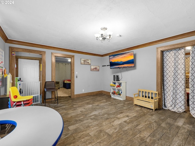 rec room with a chandelier, a textured ceiling, dark hardwood / wood-style floors, and crown molding