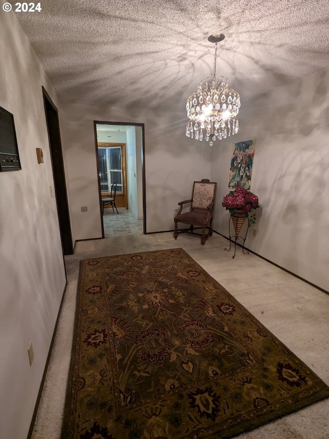 hallway with a chandelier and a textured ceiling