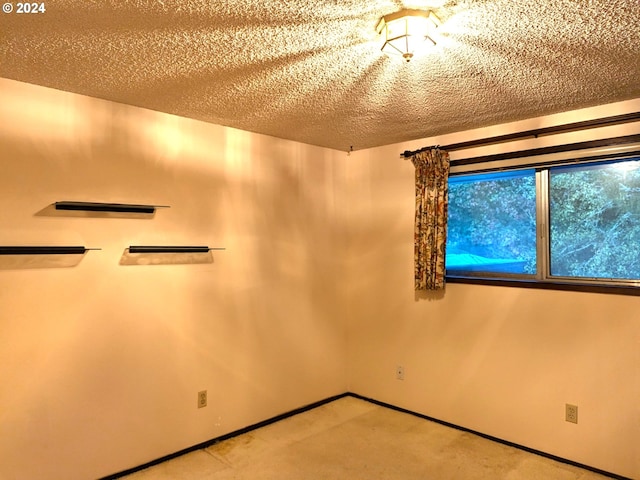 carpeted spare room with baseboards and a textured ceiling