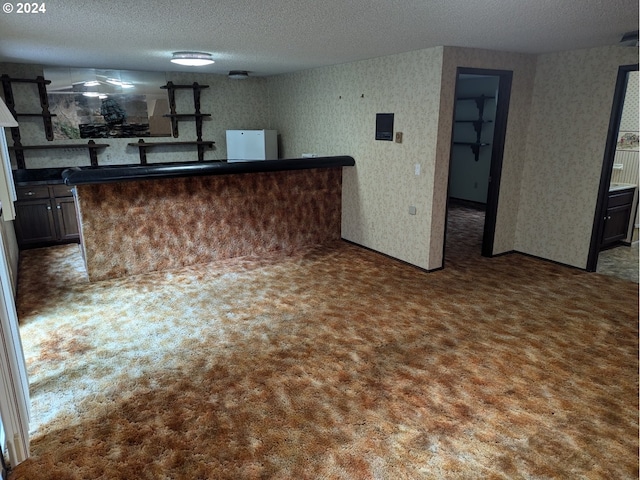 kitchen with carpet floors, a textured ceiling, and white refrigerator