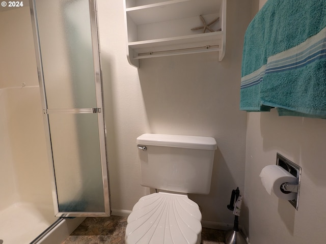 full bath with toilet, a stall shower, and baseboards