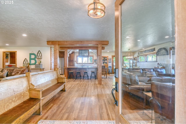 bedroom with a textured ceiling, wood-type flooring, sink, and stainless steel refrigerator