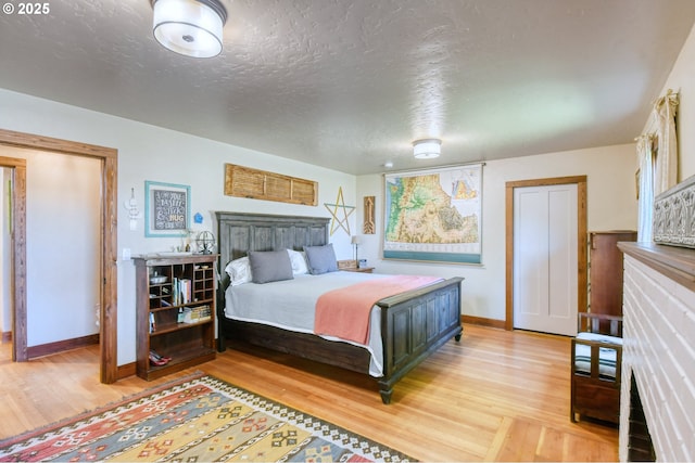 bedroom with a textured ceiling and light hardwood / wood-style floors