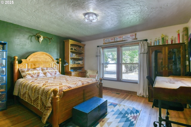 bedroom featuring hardwood / wood-style flooring and a textured ceiling