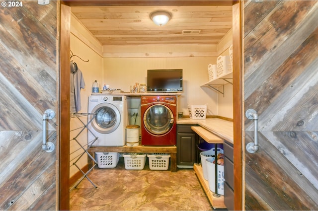 laundry area featuring wooden ceiling, wooden walls, and separate washer and dryer