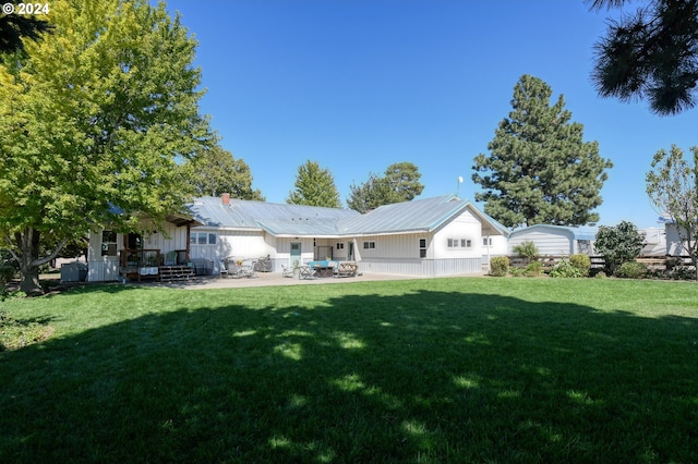 back of property featuring a patio area and a yard