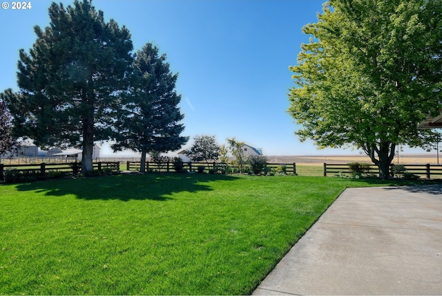 view of yard with a rural view and a patio