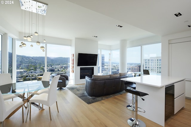 living room with wine cooler, a wealth of natural light, and light wood-type flooring