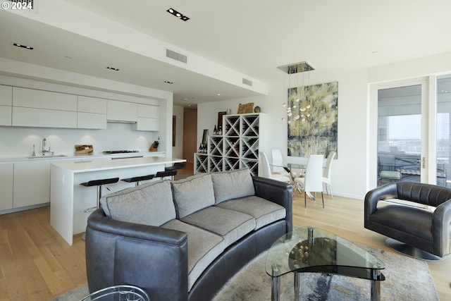 living room with sink and light hardwood / wood-style floors