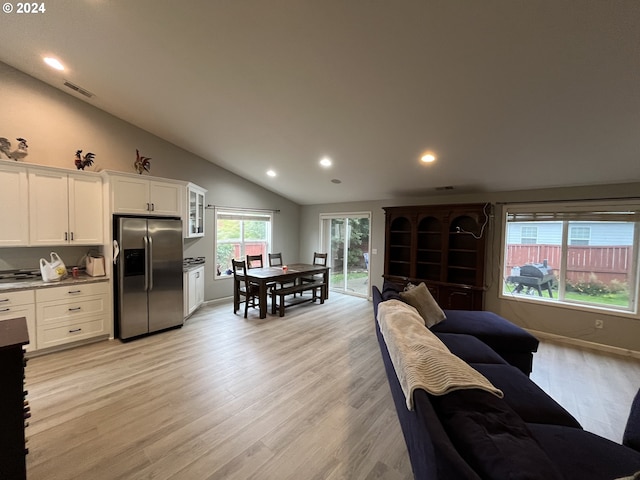 living room with light hardwood / wood-style flooring and vaulted ceiling