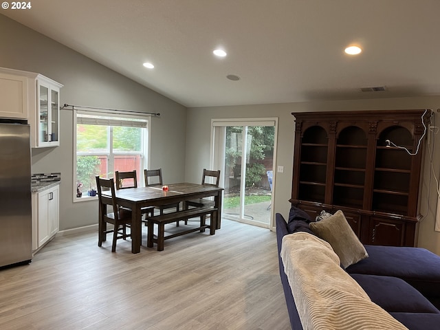 dining room featuring vaulted ceiling, light hardwood / wood-style floors, and plenty of natural light