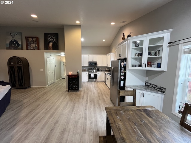 kitchen with white cabinets, stainless steel appliances, plenty of natural light, and light hardwood / wood-style flooring