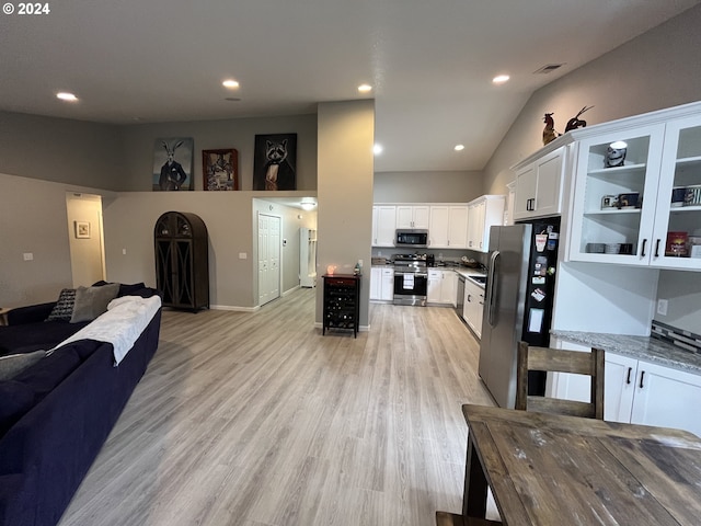 interior space with light wood-type flooring and lofted ceiling