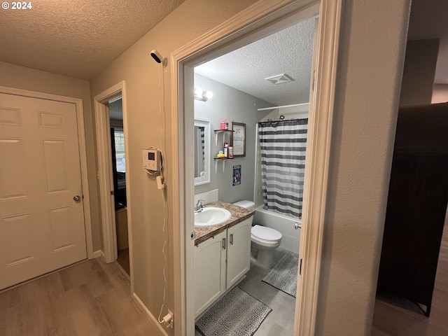 full bathroom with a textured ceiling, vanity, toilet, and shower / bathtub combination with curtain