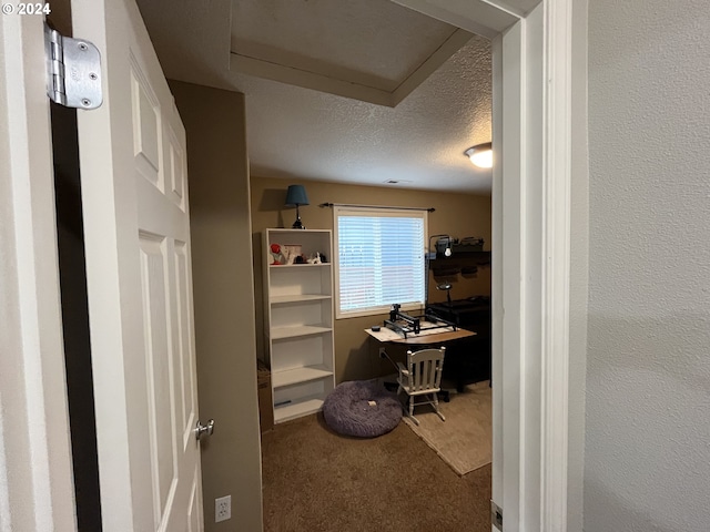 carpeted office featuring a textured ceiling