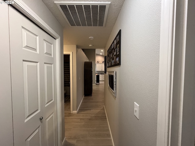 hallway with hardwood / wood-style flooring