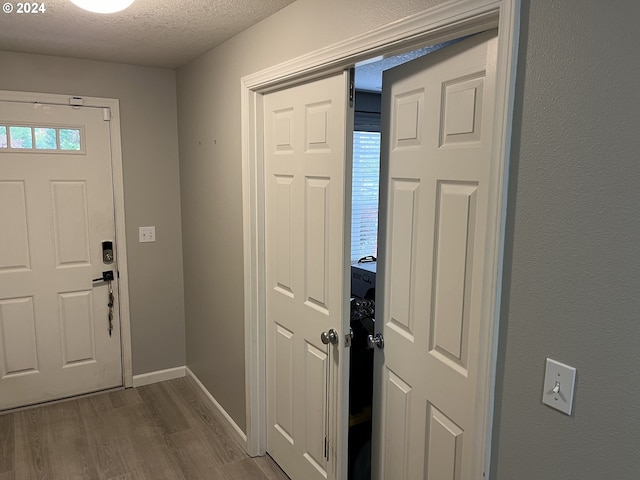 foyer entrance with a textured ceiling and dark hardwood / wood-style floors