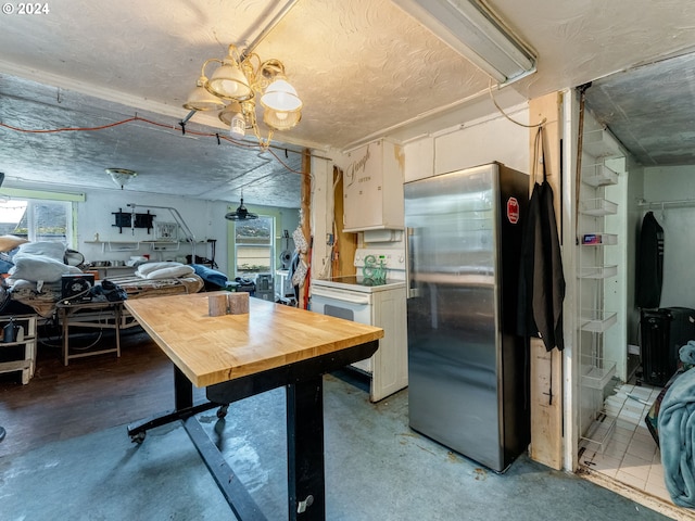 kitchen featuring white cabinetry, stainless steel fridge, and white electric stove